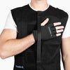 Detailed shot of the Shoulder It glove attachment with visible branding. The hand is held in place across the padded vest panel, demonstrating the vest's secure yet adjustable design ideal for sleeping after shoulder surgery such as rotator cuff or labral repair.