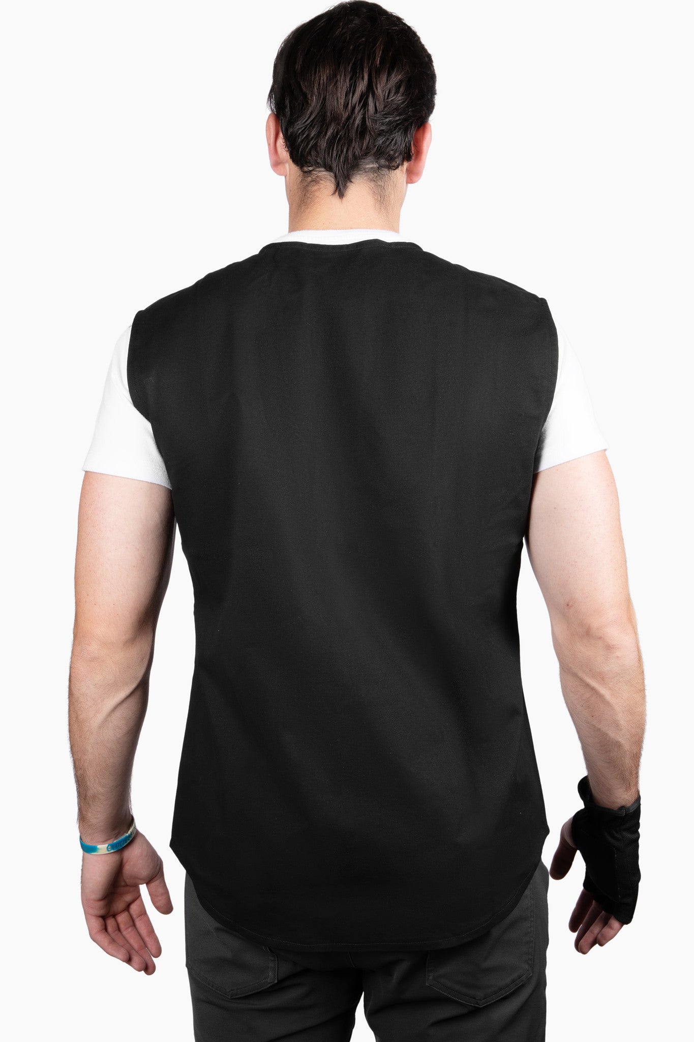 Back view of a man wearing the Shoulder It recovery vest, showing a smooth, strap-free design with no rings or bulky components pressing into his spine. Unlike traditional shoulder slings, Shoulder It eliminates the discomfort of neck straps and back hardware, making it easier to sleep after shoulder surgery like a rotator cuff repair or labrum tear. The vest contours naturally to the body, supporting pain-free rest during recovery.